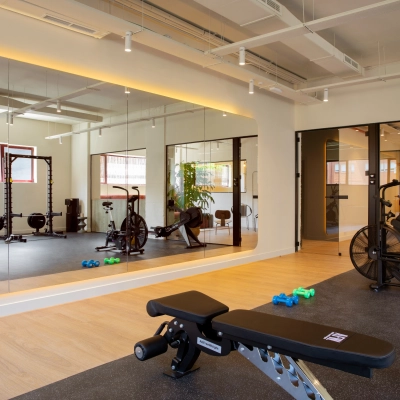 Moderno espacio de alquiler de oficinas en Paseo Imperial 14, Madrid Centro, con área de gimnasio y equipo de fitness.