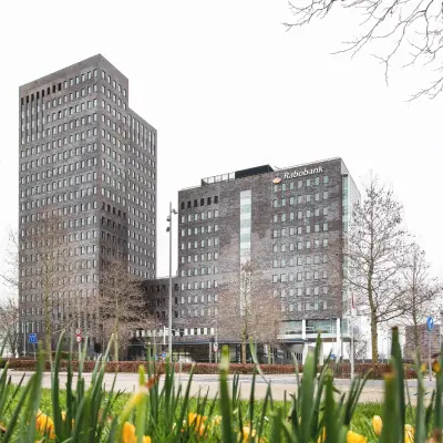 Kantoorpand aan de Landdrostdreef 124 in Almere Stad met moderne architectuur, omringd door groen en een open straat. Ideaal voor bedrijven die kantoorruimte willen huren in een levendige zakelijke omgeving.