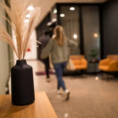 Moderne kantoorruimte huren in Almere Stad aan Markerkant 1310, met stijlvolle inrichting. Twee personen lopen door een gang langs comfortabele stoelen en decoratieve elementen.