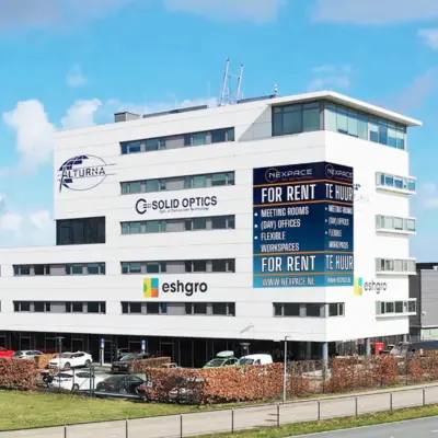 Modern kantoorpand te huur op Veluwezoom 15, Almere Stad, met opvallende gevelreclames voor diverse bedrijven.