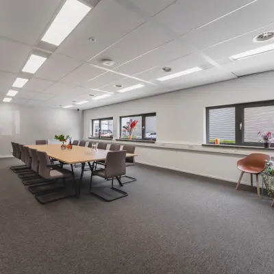 Ruime kantoorruimte te huur op Veluwezoom 15 in Almere Stad, met een lange vergadertafel en moderne stoelen, geschikt voor vergaderingen of coworking.