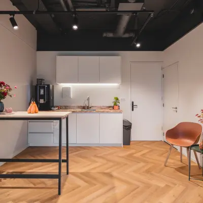 Moderne kantoorruimte met een nette pantry en houten vloer, ideaal voor wie kantoorruimte wil huren in Almere Stad, Veluwezoom 15.