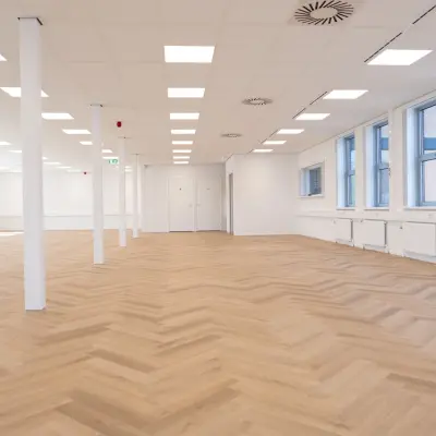 Ruime, lichte kantoorruimte huren op Maanlander 43 in Amersfoort Calveen, met grote ramen en houten vloer, geschikt voor diverse zakelijke activiteiten.