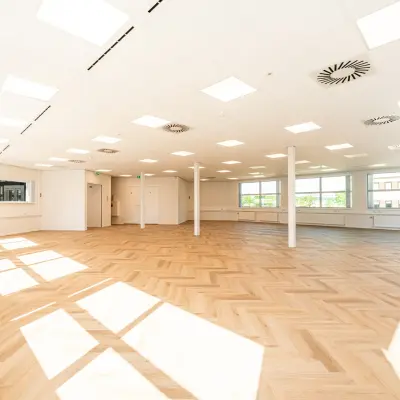 Ruime en lichte kantoorruimte te huur op Maanlander 43, Amersfoort Calveen. Grote ramen zorgen voor natuurlijk licht over de houten vloer, ideaal om kantoren volledig naar wens in te richten.