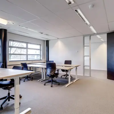 Lichte kantoorruimte te huur op Maanlander 47, Amersfoort Calveen, met moderne bureaus en stoelen, ideaal voor professionele werkomgeving.