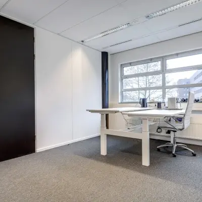 Lichte kantoorruimte met groot bureau en moderne stoel, gelegen op Maanlander 47, Amersfoort Calveen. Ruimte geschikt voor kantoorwerkzaamheden of als werkplek te huur.