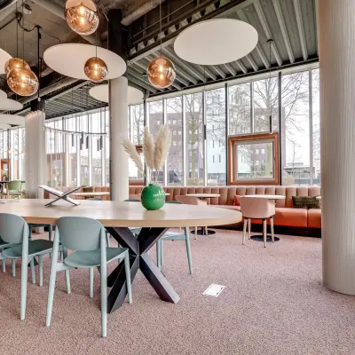Stijlvolle kantoorruimte te huur op Maanlander 47 in Amersfoort Calveen, met een grote tafel en moderne verlichting, ideaal voor vergaderingen in een open en lichte omgeving.