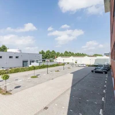 Buitenzijde van kantoorpand aan Spoetnik 10-64 in Amersfoort Calveen met parkeerplaats en omliggende gebouwen.