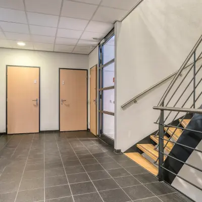 Ingang van kantoorpand Asch van Wijckstraat 2-4 in Amersfoort Centrum met tegelvloer, trap en lift. Kantoorruimte huren in een modern gebouw.