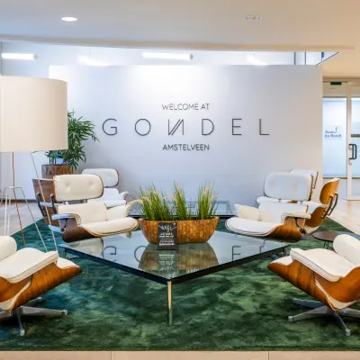 Moderne lobby van kantoorpand op De Gondel 1, Amstelveen, met stijlvolle stoelen en een glazen tafel, ideaal om te overleggen of bezoekers te ontvangen. Perfect voor wie kantoorruimte wil huren in Amstelveen.