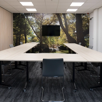 Kantoorpand Handelsweg 53 in Amstelveen, professionele vergaderruimte met een serene bosachtergrond, moderne tafels en stoelen, ideaal voor vergaderingen of presentaties. Perfect voor wie kantoorruimte wil huren.