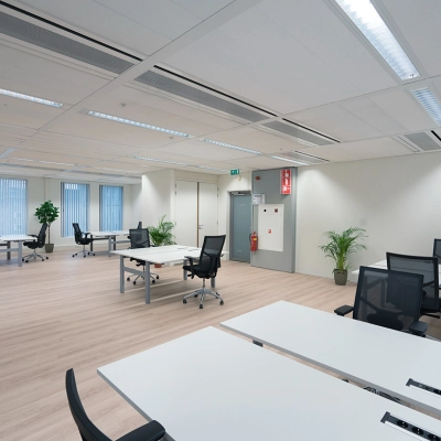 Ruime kantoorruimte huren in Amstelveen met moderne werkplekken. Voorzien van bureaus, stoelen en decoratieve elementen zoals planten en lampen, biedt deze ruimte een schone, professionele omgeving voor bedrijven.