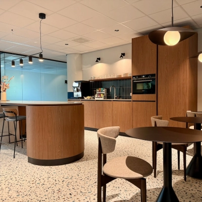 Moderne, lichte kantoorpand pantry op Professor E.M. Meijerslaan 1 in Amstelveen met ronde tafels, barkrukken en ingebouwde keukenapparatuur. Perfect om kantoorruimte te huren voor creatieve pauzemomenten en informele vergaderingen.