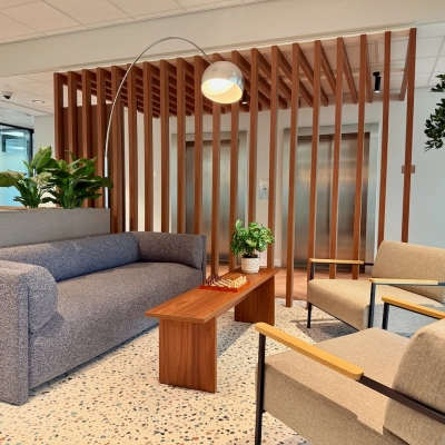 Moderne kantoorruimte aan Professor E.M. Meijerslaan 1 in Amstelveen met comfortabele zitbanken, houten elementen en groene planten, ideaal voor ontspanning en informele gesprekken.