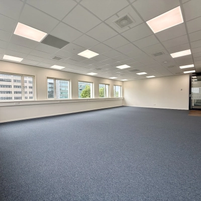 Lege kantoorruimte op Professor E.M. Meijerslaan 1, Amstelveen, met witte muren, een blauw tapijt en meerdere ramen die natuurlijk licht binnenlaten.