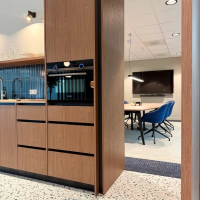 Moderne kantoorruimte met een volledig ingerichte pantry en zicht op een vergadertafel in een functionele kantooromgeving in Amstelveen.