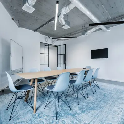 Moderne kantoorruimte met een lange tafel en blauwe stoelen op H.J.E. Wenckebachweg 90-108, geschikt voor vergaderingen of teamwork in Amsterdam Amstel Business Park.