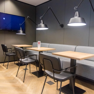 Moderne kantoorruimte met houten vloer en stijlvolle verlichting op Amstelplein 8, Amsterdam Amstel. De ruimte beschikt over tafels en stoelen, perfect voor huur als werkplek of vergaderruimte.