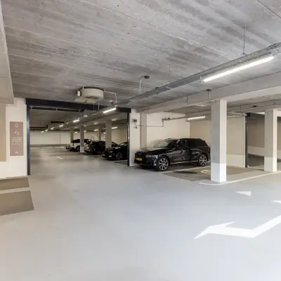 Parkeergarage van het kantoorpand op Willem Fenengastraat 16 in Amsterdam Amstel, met meerdere geparkeerde auto's en betonnen plafonds.