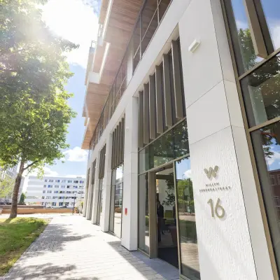 Buitenzijde van het kantoorpand aan de Willem Fenengastraat 16 in Amsterdam Amstel, ideaal voor het huren van kantoorruimte. Het moderne gebouw omgeven door groen straalt professionaliteit uit.