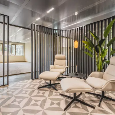 Moderne kantoorruimte op Walborg 2A in Amsterdam Buitenveldert met stijlvolle stoelen en designvloer, ideaal voor het huren van een presentabele werkplek.