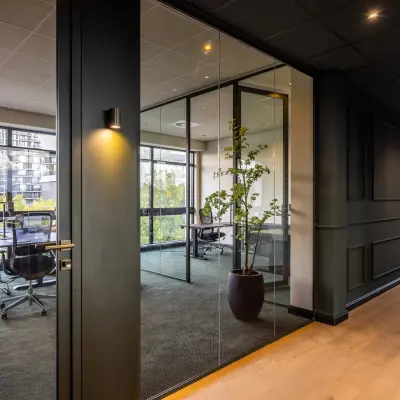 Moderne kantoorruimte huren in Amsterdam Buitenveldert aan Zwaansvliet 1, voorzien van glazen wanden, kantoorstoelen en uitzicht op de stad. Geschikt voor vergaderingen en werkgelegenheden.