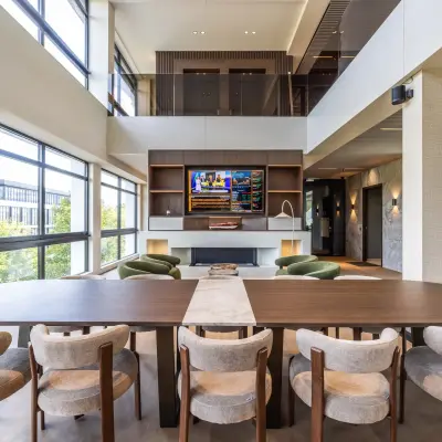 Moderne kantoorruimte in Amsterdam Buitenveldert met een grote tafel en comfortabele stoelen, ideaal om te huren als werkruimte. Het interieur is ruim en licht met uitzicht over de stad.