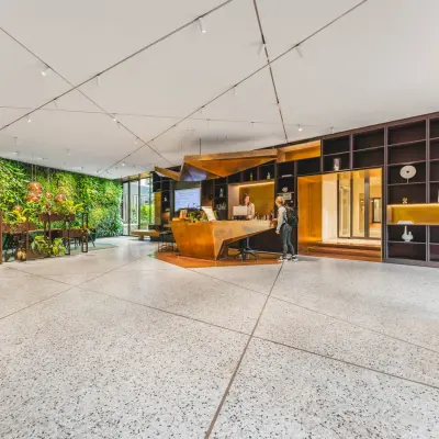 Lichte en moderne kantoorruimte aan de Herengracht 471 in Amsterdam Centrum met een groene wand en een stijlvolle receptie. Ideaal voor bedrijven die kantoorruimte willen huren in een inspirerende omgeving.