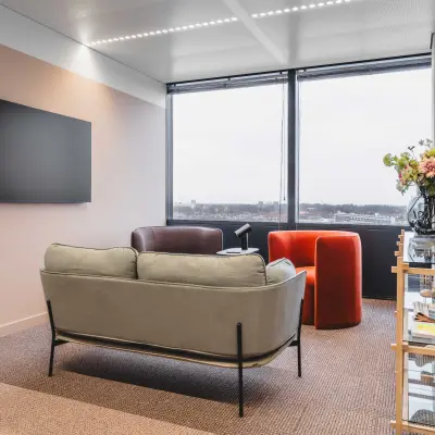 Moderne kantoorruimte huren aan de Piet Heinkade 55 in Amsterdam Centrum, met comfortabele zitbank, fauteuil en grote ramen die uitzicht bieden op de stad.