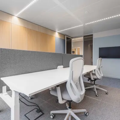 Moderne kantoorruimte met houten panelen op Piet Heinkade 55, Amsterdam Centrum, geschikt voor het huren van een kantoorpand. Meubilair bestaat uit witte bureaus en comfortabele stoelen.