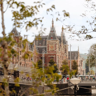 Uitzicht op een historisch kantoorpand aan de Prins Hendrikkade 14 in Amsterdam Centrum, gelegen aan het water met architectonische details.