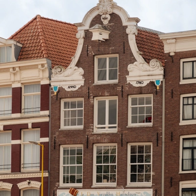 Gevel van een historisch kantoorpand op Prins Hendrikkade 14 in Amsterdam Centrum, karakteristieke architectuur, beschikbaar voor kantoorruimte huur.