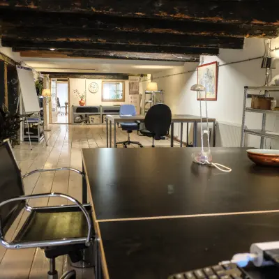 Kantoorruimte huren op Prinseneiland 23A in Amsterdam Centrum met houten balkenplafond en moderne meubels, geschikt voor verschillende werkactiviteiten.