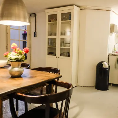 Gezellige kantoorruimte met houten tafel, stoelen en een keukentje op Prinseneiland 23A, Amsterdam Centrum. Ideaal voor kantoorruimte huren met een huiselijke sfeer.