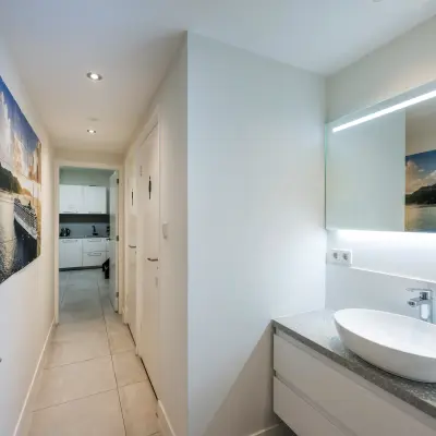 Moderne en strakke kantoorruimte met wastafel in Amsterdam Centrum, ideaal voor wie een kantoorpand wil huren. De ruimte heeft een lichte inrichting met kunst aan de muur.