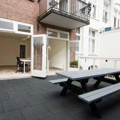 Kantoorruimte huren aan de Warmoesstraat 149-151 in Amsterdam Centrum met toegang tot een terras met picknicktafel. Binnenruimte is ongemeubileerd, ideale plek voor creatieve werkplekken.