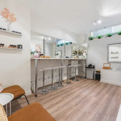 Gezellig ingerichte kantoorruimte op Warmoesstraat 155, Amsterdam Centrum, met hoge stoelen, houten vloer en decoratieve planten. Ideaal voor creatieve werkplekken en meetings.