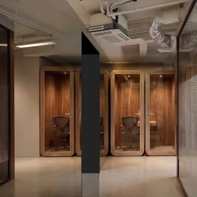 Moderne kantoorruimte op Weteringschans 26 in Amsterdam Centrum met strakke design elementen en telefoonhokjes, ideaal voor verhuur.