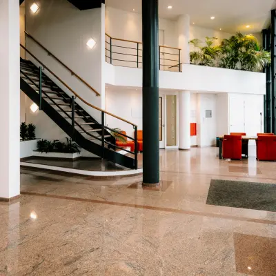 Ruime entree van een kantoorpand met een glanzende marmeren vloer, moderne trap, en zitgedeelte op Overschiestraat 182 te Amsterdam De Schinkel.