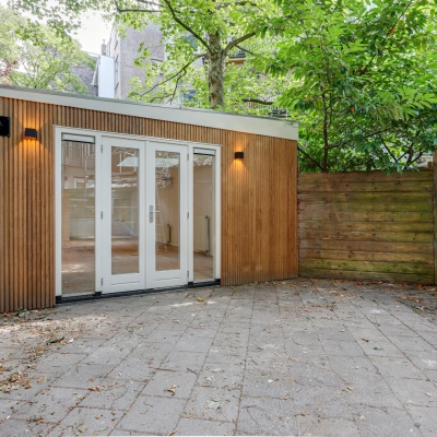 Exterieur van een kantoorpand met houten gevel en glazen deuren op Schinkelkade 44 in Amsterdam De Schinkel. Ideaal voor kantoorruimte huren met een rustige buitenruimte.