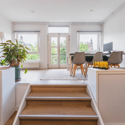 Kantoorruimte aan de Herengracht 221 in Amsterdam Grachtengordel met uitzicht op de gracht. De ruimte is gemeubileerd met een tafel, stoelen en planten, ideaal voor kantoorruimte huren.