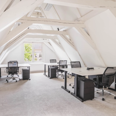 Lichte en ruime kantoorruimte aan de Herengracht 221 in Amsterdam Grachtengordel, voorzien van bureaus en stoelen. Deze open werkruimte biedt een uitnodigende omgeving voor bedrijven die een kantoorpand willen huren.