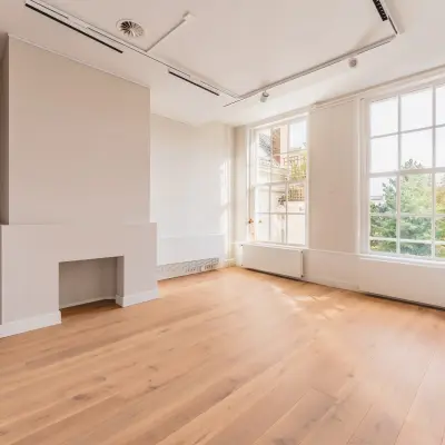 Lichte kantoorruimte te huur aan de Herengracht 582-584 in Amsterdam Grachtengordel, met houten vloer en grote ramen voor veel natuurlijk licht.