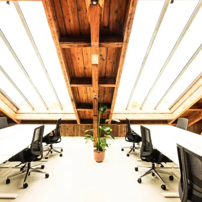 Ruimte met houten plafond en veel daglicht op Keizersgracht 264. Moderne kantoorruimte huren in Amsterdam Grachtengordel met bureaus en stoelen, ideaal voor creatieve werkplekken.