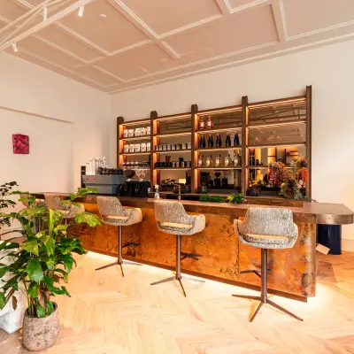 Modern ingerichte lounge met een stijlvolle bar, planten en comfortabele zitjes in een kantoorpand aan de Keizersgracht 264 in Amsterdam Grachtengordel. Kantoorruimte huren met een eigentijdse uitstraling.