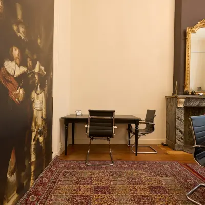 Kantoorruimte te huur op Keizersgracht 391A, Amsterdam, met klassieke inrichting, tapijt en kunstwerken aan de muur. Geschikt voor zakelijke activiteiten.