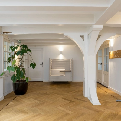 Kantoorruimte te huur op Keizersgracht 452, Amsterdam Grachtengordel, met een houten vloer, een plant in de hoek en een zithoek bij de muur.
