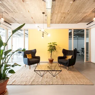 Moderne kantoorruimte met comfortabele stoelen en glazen tafel, omgeven door planten, te huur op Singel 542 in de Amsterdam Grachtengordel.