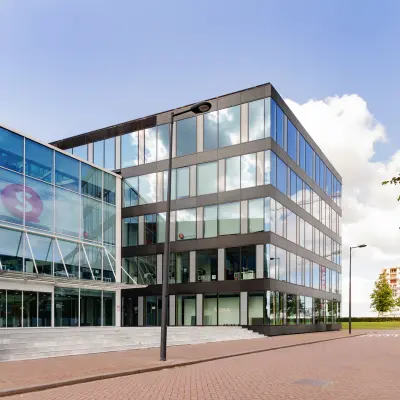 Modern kantoorpand aan de Pedro de Medinalaan 1-9 in Amsterdam IJburg met glazen gevels en ruime entree. Ideaal voor bedrijven die kantoorruimte willen huren.