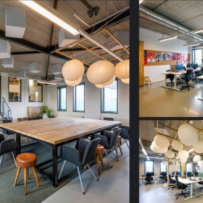 Moderne en lichte kantoorruimte huren in Amsterdam Noord, Meeuwenlaan 98-100. Ruime werkplekken met hangende lampen en voldoende daglichtinval. Comfortabele zithoek met stoelen rondom een tafel.